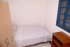 Habitación pequeña con cama y puerta azul en Apto c Wifi e otima localizacao em Santa Rosa RS, en Santa Rosa