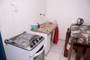 una pequeña cocina con fogones y fregadero en Apto c Wifi e otima localizacao em Santa Rosa RS en Santa Rosa