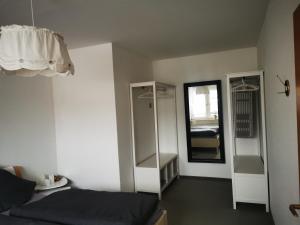 ein kleines Zimmer mit einem Bett und einem Spiegel in der Unterkunft Ferienwohnung Flüburg in Diemelstadt 
