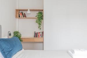 a bedroom with a bed and a shelf with books at Fliphaus Melo 2900 - 1 Bd Alto Palermo in Buenos Aires