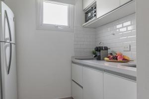 a white kitchen with a bowl of fruit on the counter at Fliphaus Melo 2900 - 1 Bd Alto Palermo in Buenos Aires