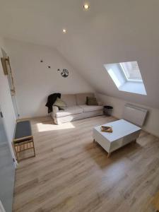 a living room with a white couch and a window at Cosy appartement proche Disneyland in Étampes-sur-Marne