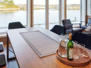 a table with a bottle of wine and glasses on it at Holiday home Averøy VII in Karvåg