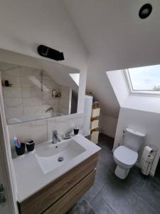 a bathroom with a white sink and a toilet at Cosy appartement proche Disneyland in Étampes-sur-Marne