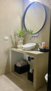 baño con lavabo y espejo en una mesa en Yellow Cardinal Lodge, en Curuzú Cuatiá