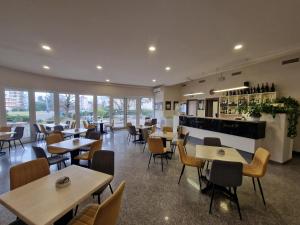 um restaurante com mesas e cadeiras e um bar em Modo Hotel em Vercelli