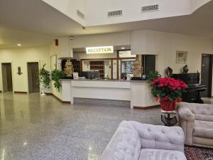a lobby with two couches and a reception counter at Modo Hotel in Vercelli