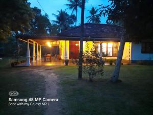 una casa con porche por la noche en Villa Oasis, en Weligama