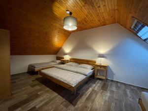 a bedroom with two beds and a wooden ceiling at Pension Polonia in Vrchlabí