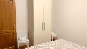 een slaapkamer met een bed en twee tafels en een deur bij Confortevole Appartamento con Piscina in Castiglione del Lago