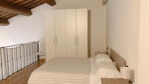 a bedroom with a bed with white cabinets at SulLago Appartamenti - Confortevole Appartamento con Piscina in Castiglione del Lago