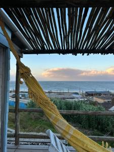 een hangmat op een veranda met uitzicht op de oceaan bij NewViejoBlanco in Punta Del Diablo