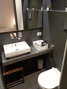 ein Badezimmer mit Waschbecken und Toilette in der Unterkunft Mutina Suites in Modena