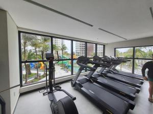 a gym with several treadmills in a room with windows at Salinas Premium resort in Salinópolis