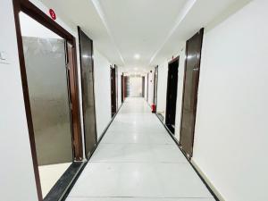 un pasillo de un edificio vacío con puertas y un pasillo largo en Hotel Pleasure, en Surat