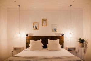 ein Schlafzimmer mit einem großen weißen Bett mit zwei Lampen in der Unterkunft La Sosta in Swellendam