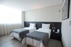 Postel nebo postele na pokoji v ubytování Tryp by Wyndham Belo Horizonte Savassi