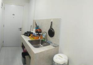 a kitchen with a sink and a counter at Astara Hotel Balikpapan in Balikpapan