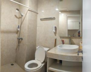 a bathroom with a toilet and a sink at Astara Hotel Balikpapan in Balikpapan