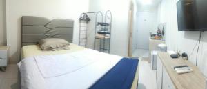 a bedroom with a bed and a desk with a television at Astara Hotel Balikpapan in Balikpapan