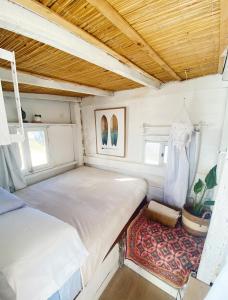 a small bedroom with a bed and a rug at Salty House Cabo Polonio in Cabo Polonio