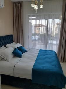 a large bed with blue pillows in a bedroom at Holiday Dreams Sweetwater Bay in Akanthou