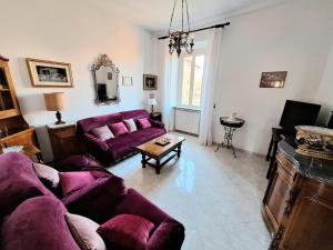 a living room with a purple couch and a table at CASA MARIA in Castel del Piano