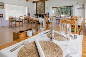 a dining room with a table with wine glasses on it at La Sosta in Swellendam