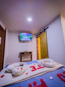 a bedroom with a bed with red flowers on it at Canoa Abraão in Abraão