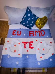 a bed with two pillows and a sign that reads el hit me at Canoa Abraão in Abraão