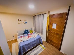 een kleine slaapkamer met een bed en een houten deur bij Canoa Abraão in Abraão