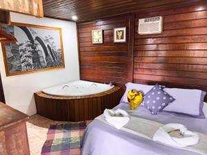 a bedroom with a bath tub and a bed at Canoa Abraão in Abraão