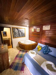 a room with two beds and a bath tub at Canoa Abraão in Abraão