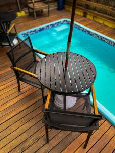 a table and chairs next to a swimming pool at Canoa Abraão in Abraão