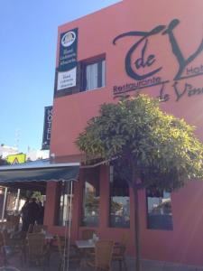 un restaurante con un árbol frente a un edificio en Hotel León Tierra de Vinos, en La Palma del Condado