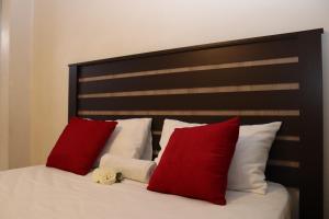 a bed with red and white pillows on it at GLESTER GUEST HOUSE in Pretoria