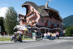 een groep mensen die voor een gebouw staan bij Motorradhotel Gailtaler Hof in Kötschach
