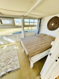 a bedroom with a bed in a room with windows at Salty House Cabo Polonio in Cabo Polonio