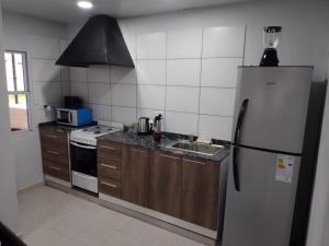 a kitchen with a refrigerator and a sink at CASA QUINTA CON PILETA, GALERIA, IMPECABLE , AIRE, WIFI in Santa Rosa