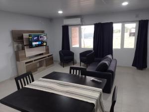 ein Wohnzimmer mit einer Couch und einem Tisch in der Unterkunft CASA quinta ""LUZ AZUL"" con pileta, galeria, calefaccion , doble aire frío calor, WIFI in Santa Rosa
