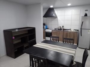 eine Küche mit einem schwarzen Tisch und einem Kühlschrank in der Unterkunft CASA quinta ""LUZ AZUL"" con pileta, galeria, calefaccion , doble aire frío calor, WIFI in Santa Rosa