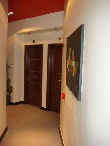 un pasillo con dos puertas y una pintura en la pared en Hotel León Tierra de Vinos, en La Palma del Condado
