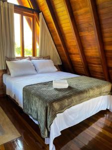 uma cama num quarto com uma janela em Chalé Villa Felicitá (Itália) em Pomerode