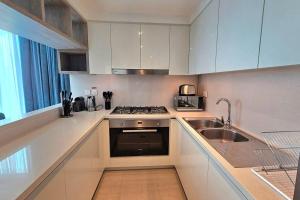 a white kitchen with a sink and a stove at Luxury 3 Bed + Maid Room in Downtown Apt With Burj Khalifa View in Dubai