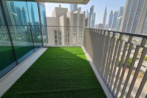 a balcony with green grass on a city skyline at Luxury 3 Bed + Maid Room in Downtown Apt With Burj Khalifa View in Dubai