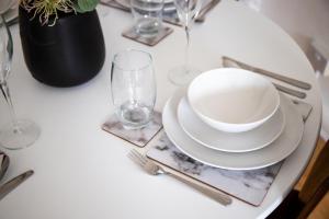 uma mesa branca com um prato e um copo em GuestReady - Homely Leeds City Apartment Sleep 4 em Meanwood