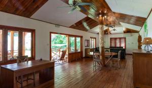 a living room with a ceiling fan and a table at JMS Ventures in La Digue