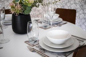 uma mesa com uma tigela branca, pratos e copos em GuestReady - Homely Leeds City Apartment Sleep 4 em Meanwood