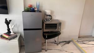 a kitchen with a microwave and a table with a chair at Paradise Gardens-Wilton Manors- Male only in Fort Lauderdale