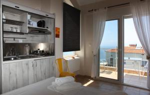 a kitchen with a view of the ocean from a balcony at Axion Esti Apartments in Skopelos Town